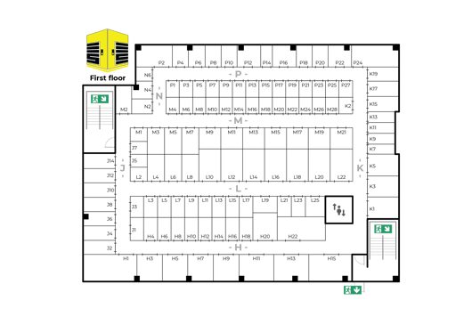A floor plan for the first floor. It shows a layout with labeled rooms and corridors organised in sections marked with letters and numbers, such as A1, B2, E3, etc. There are staircases and multiple emergency exit signs indicated with arrows pointing towards exit routes. The plan includes a yellow and black icon at the top left corner.